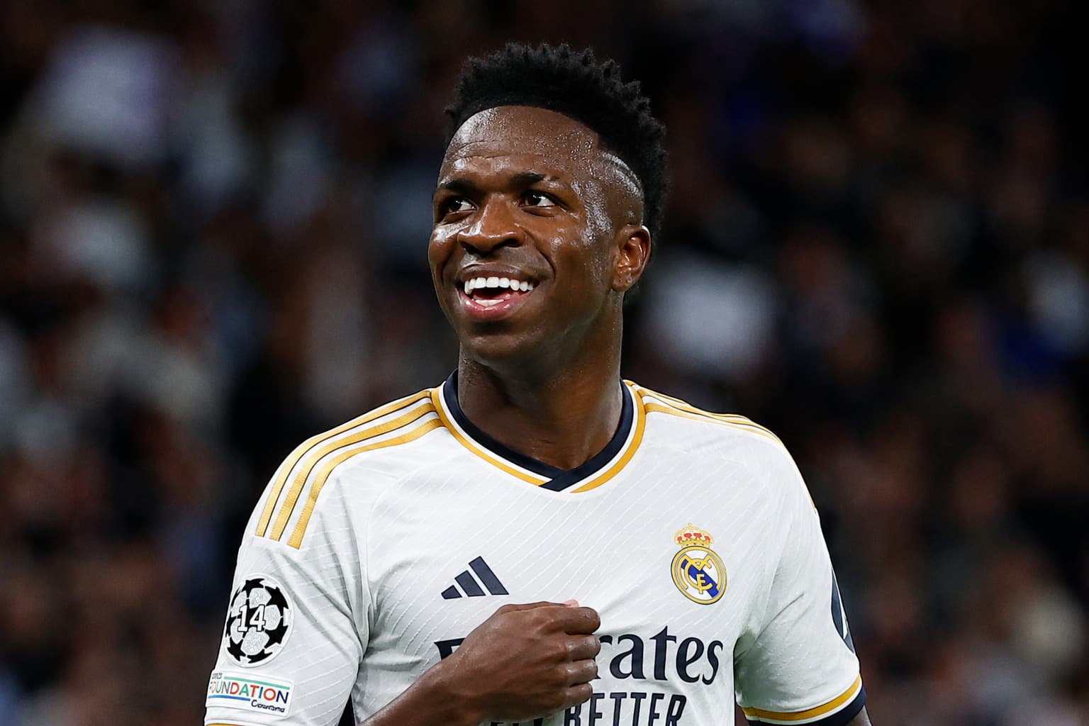 Real Madrid winger Vinícius Júnior celebrating a goal in the club's white jersey, with text announcing his contract extension until June 2032.